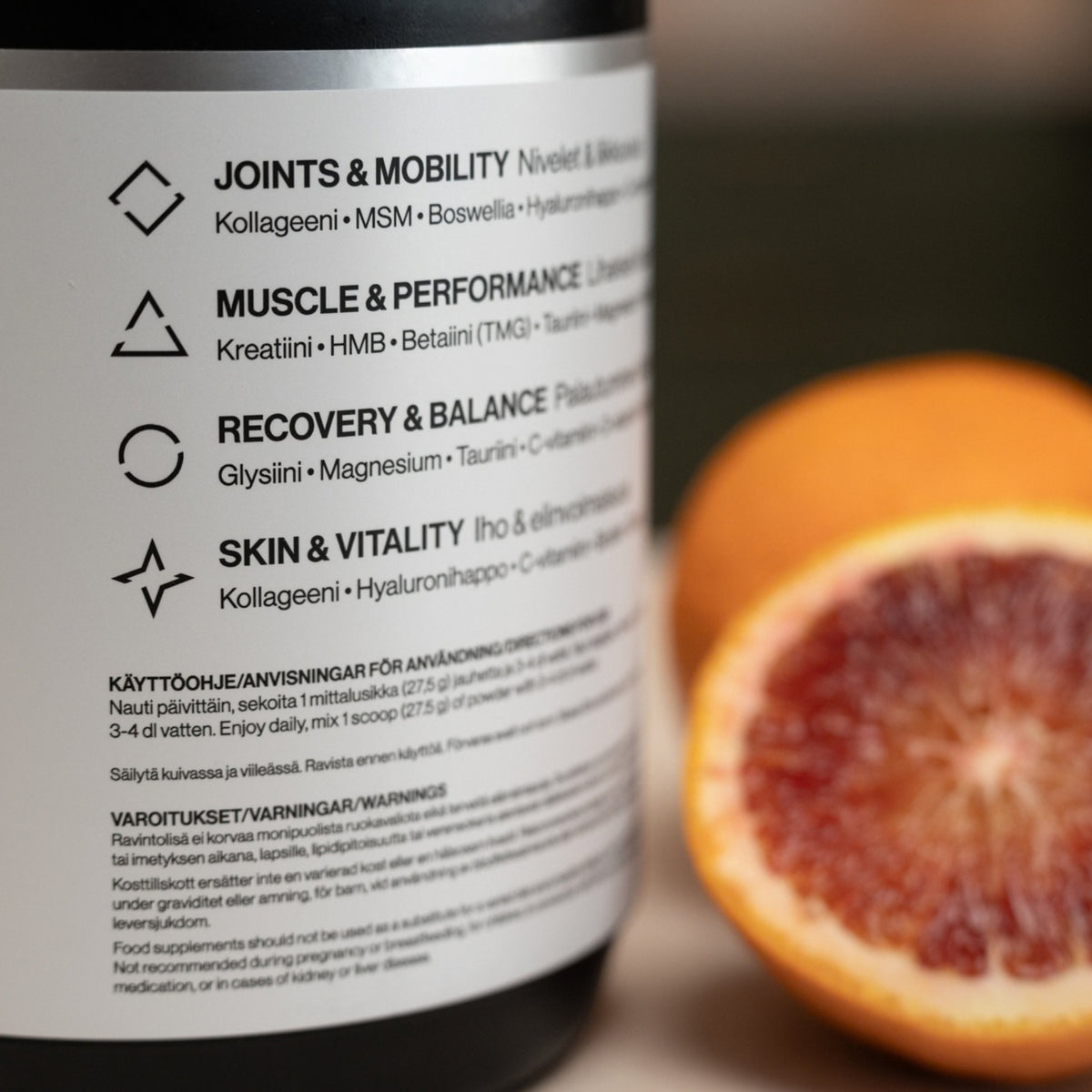 Ultimate Labs ONE Daily System -ravintolisäpurkin kyljen lähikuva, jossa lukee sen päähyödyt ja aktiiviset ainesosat