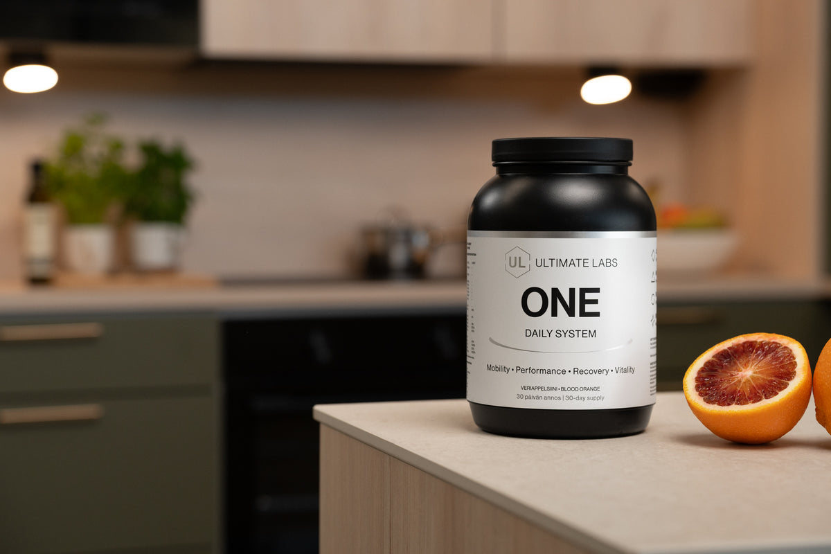 Ultimate Labs ONE Daily System -ravintolisäpurkki ja veriappelsiinit keittiössä saarekkeen kulmalla